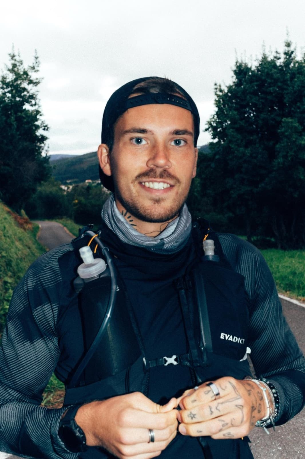 Jonathan Fors, smiling, in a running vest on a grey coastal day.