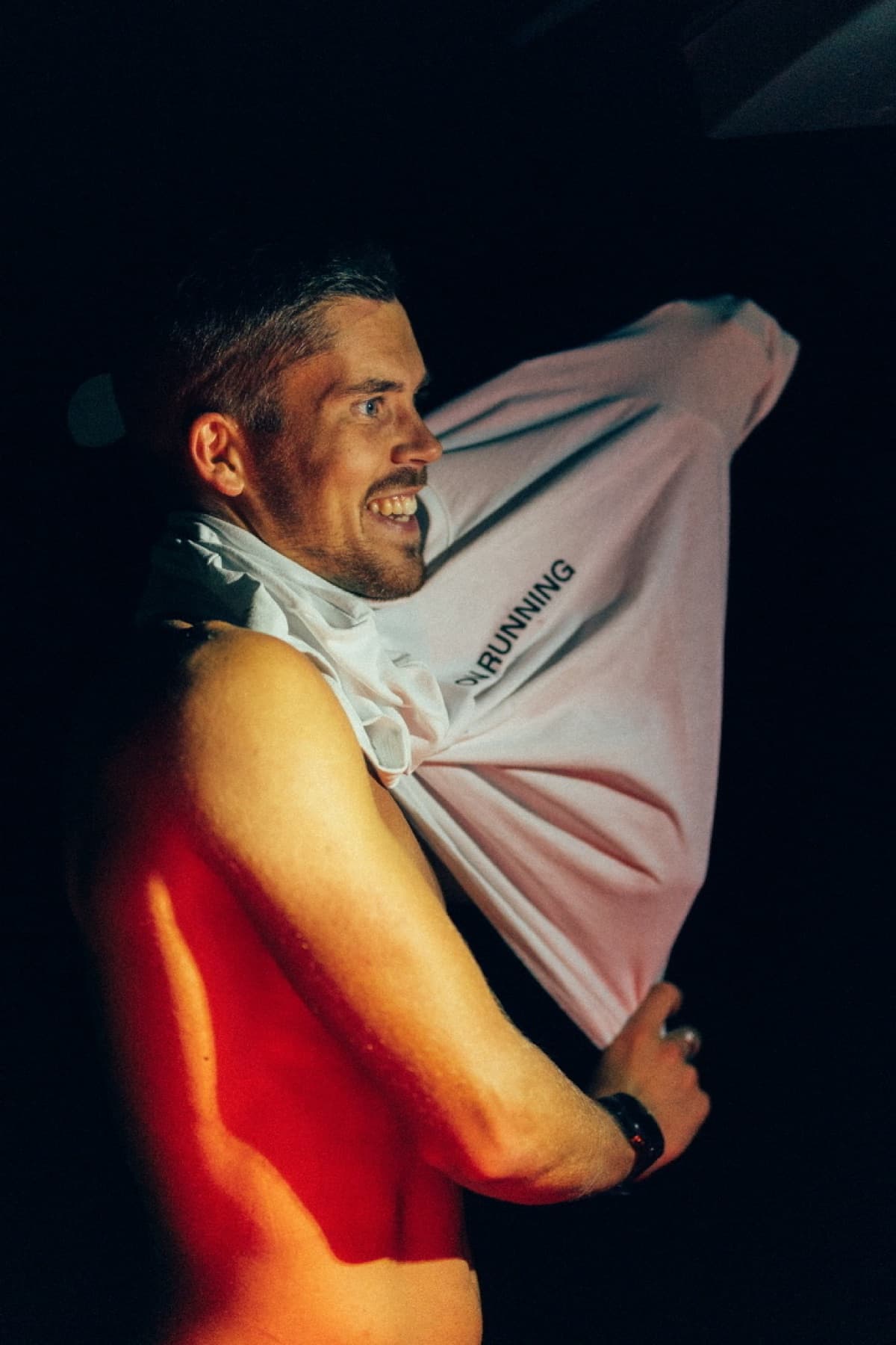 Jonathan wrapped in a thermal blanket, lit red, resting after stopping the first attempt.